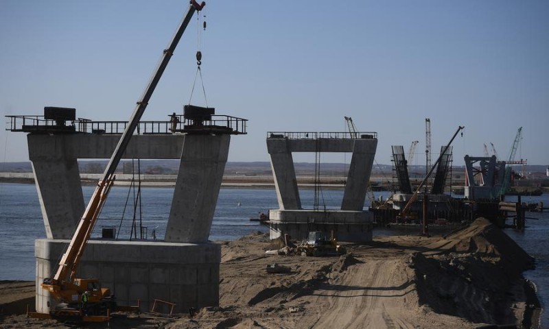 Строители возводят опоры для моста через реку Амур, который соединит Россию и Китай и станет частью проекта «Пояс и Путь». Фото: AFP / Евгений Одиноков / «Спутник».