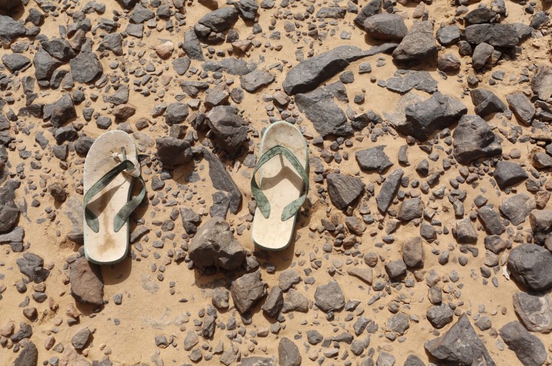 Брошенных беженцем шлёпанцы валяются в пустыне Сахара неподалёку от границы Алжира и Ливии. 